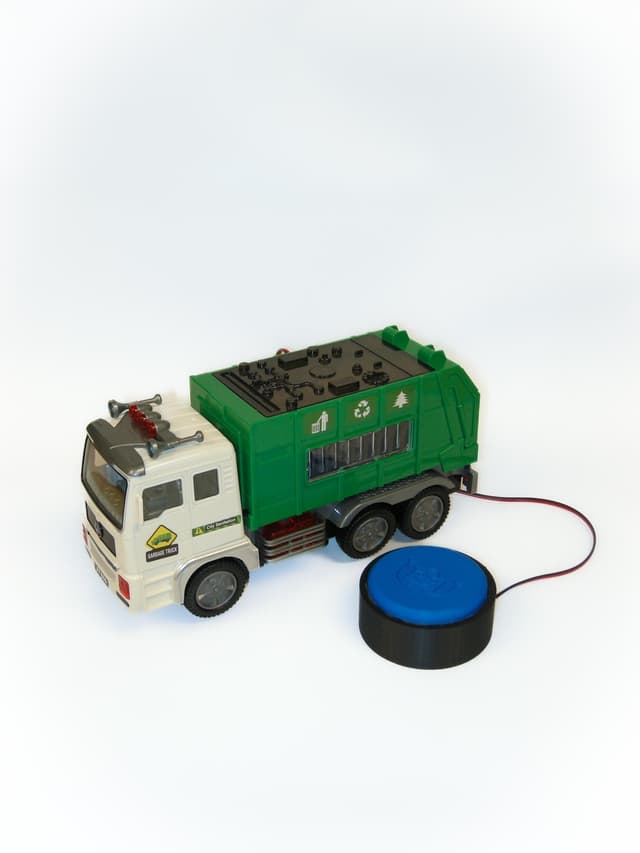 Green and white garbage truck that lights up, plays sounds, and rolls